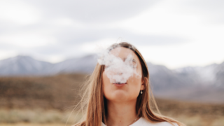 白い煙を吐く女性