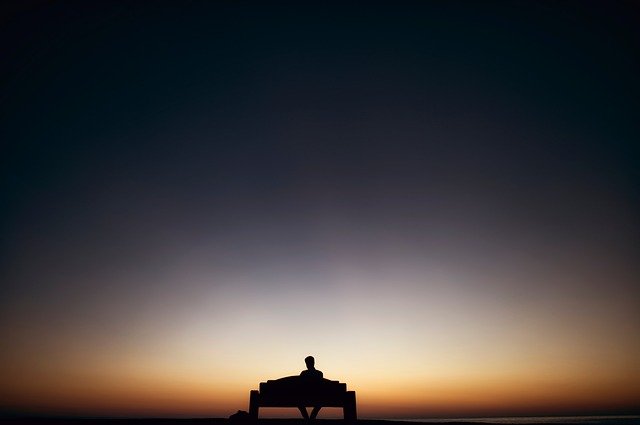 真夜中にベンチで一人座る男性